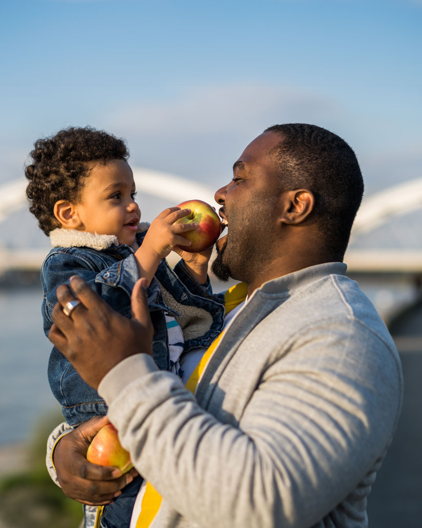 Father and son eating apple