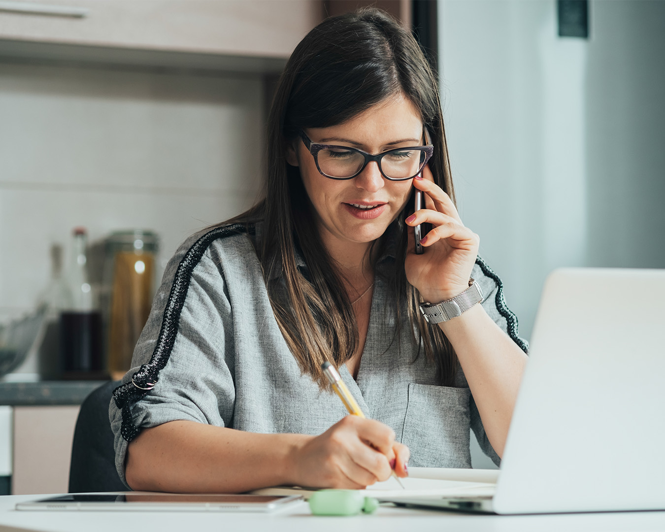 Woman talking on phone and writing notes