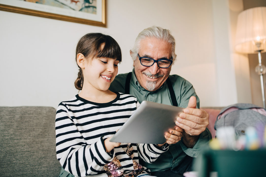 Girl and grandfather using tablet