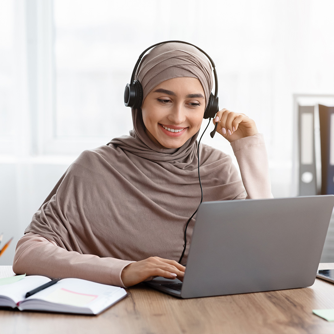 Health coach using laptop and headset