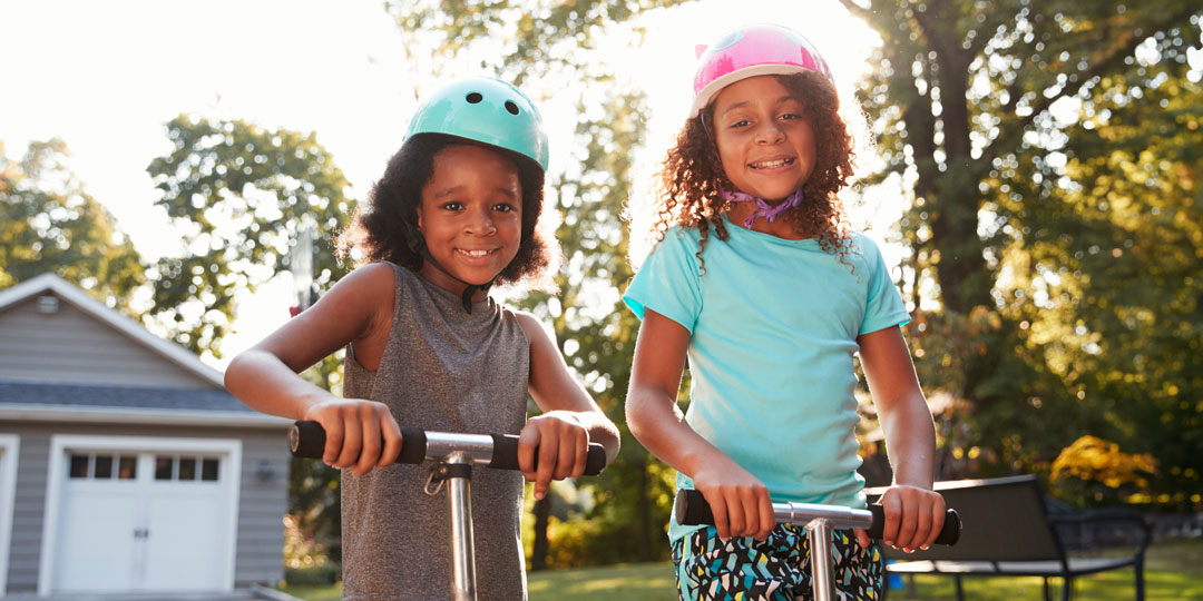 siblings riding scooters